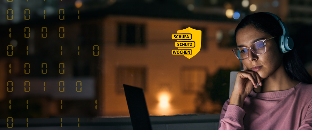 Eine Frau mit Brille und Kopfhörer sitz nachdenklich vor ihrem Laptop