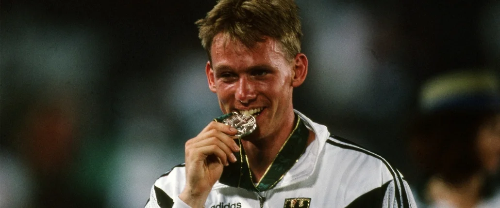 Mann hält Medaille