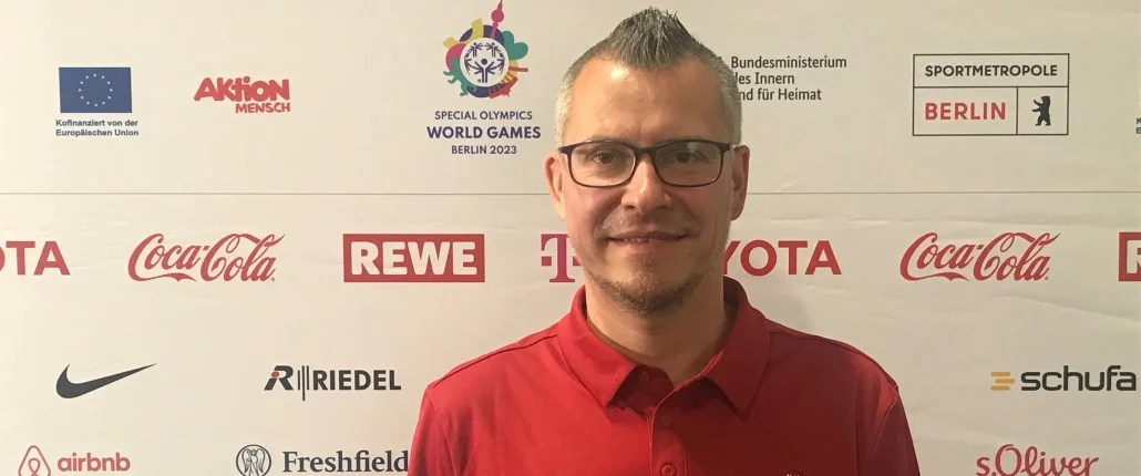 Mann lächelnd vor Pressewand