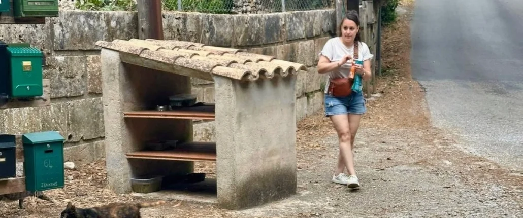 Eine Frau und eine Katze vor einer selbstgebauten Futterstelle