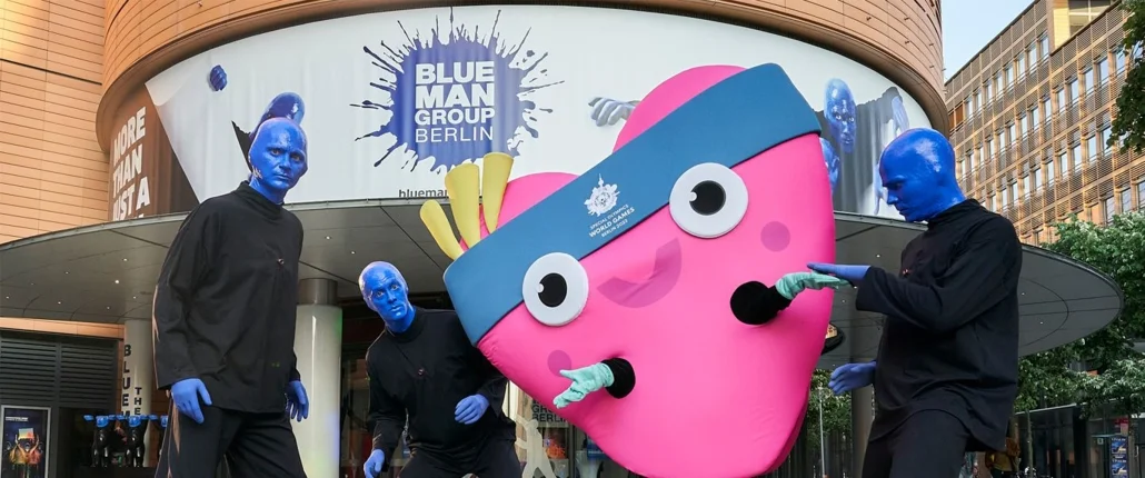 Drei blau angemalte Menschen und ein Herz als Maskottchen