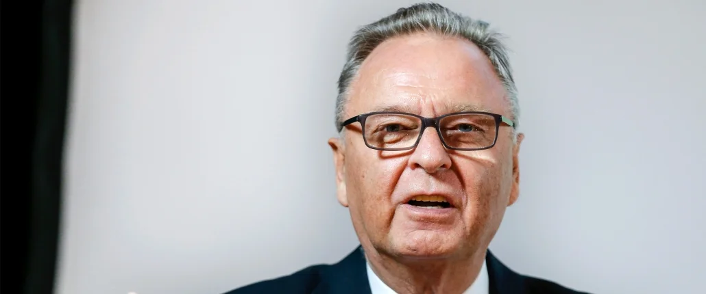 Mann lehnt sich am Tisch an